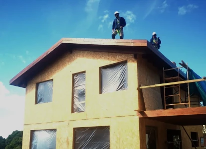 Sistema SATE colocado y listo para la aplicación del corcho proyectado de textura ELASTICOVER FINE. Casa unifamiliar de dos plantas con los obreros colocando los paneles de aislamiento térmico previo a la aplicación de Elasticover Fine.