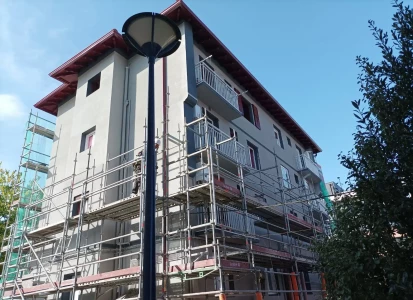 Aplicación de ELASTICOVER TECH. Edificio de cuatro plantas con andamios de obra.